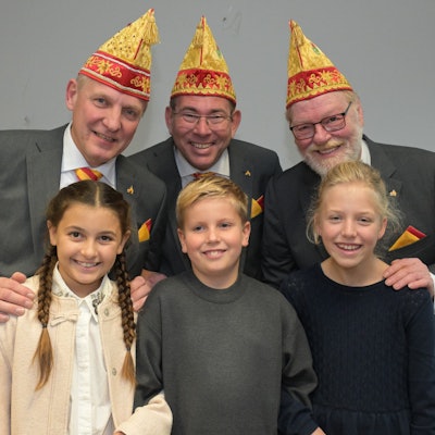 Jungfrau, Prinz und Bauer stehen hinter den beiden Mädchen und dem Jungen des Kinderdreigestirns.