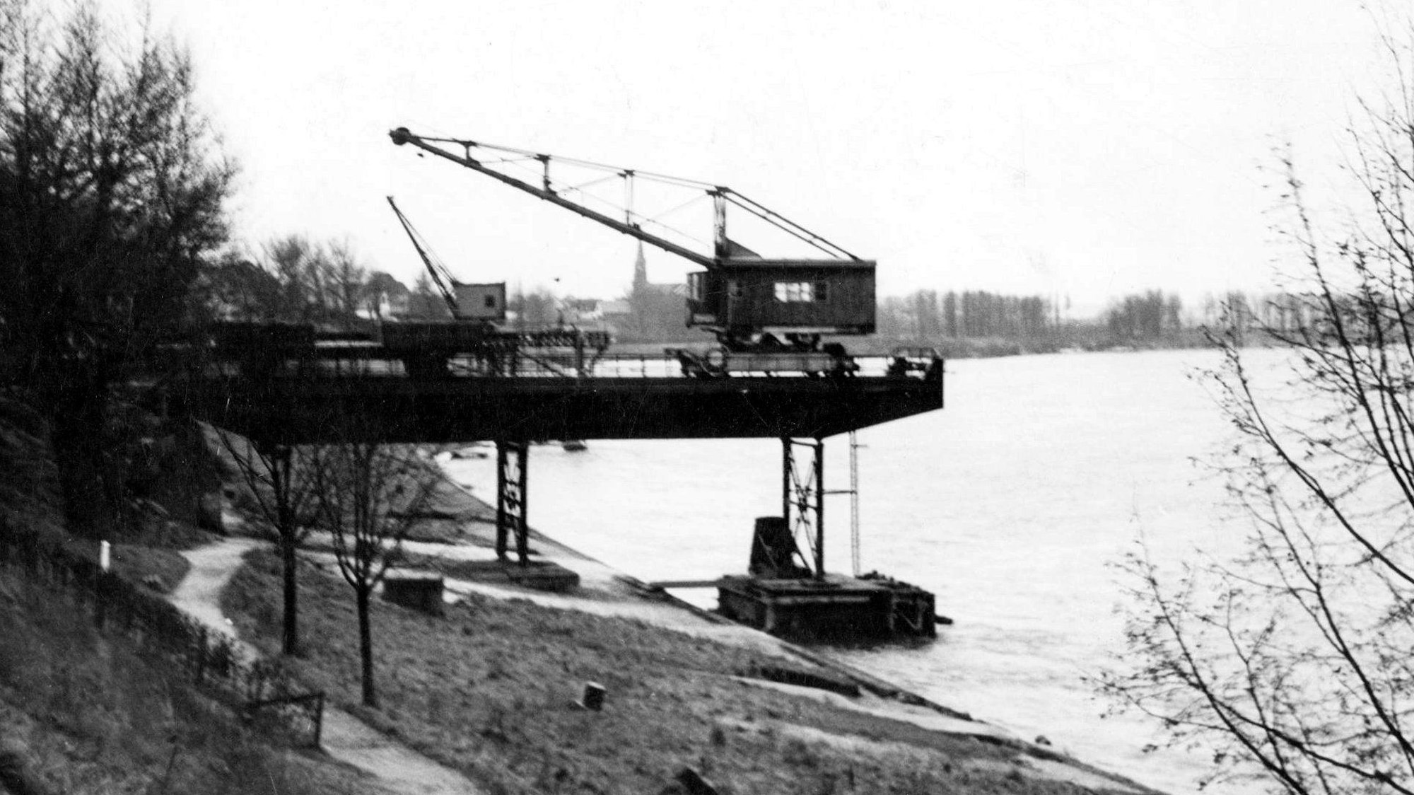 Entladekräne am Rhein waren bis in die 1970er Jahre zu sehen. Rohstoffe fürs Glas und Kohle für den Schmelzprozess wurden hier vom Schiff auf Eisenbahnbahnwaggons geladen und zu den Glaswerken transportiert.