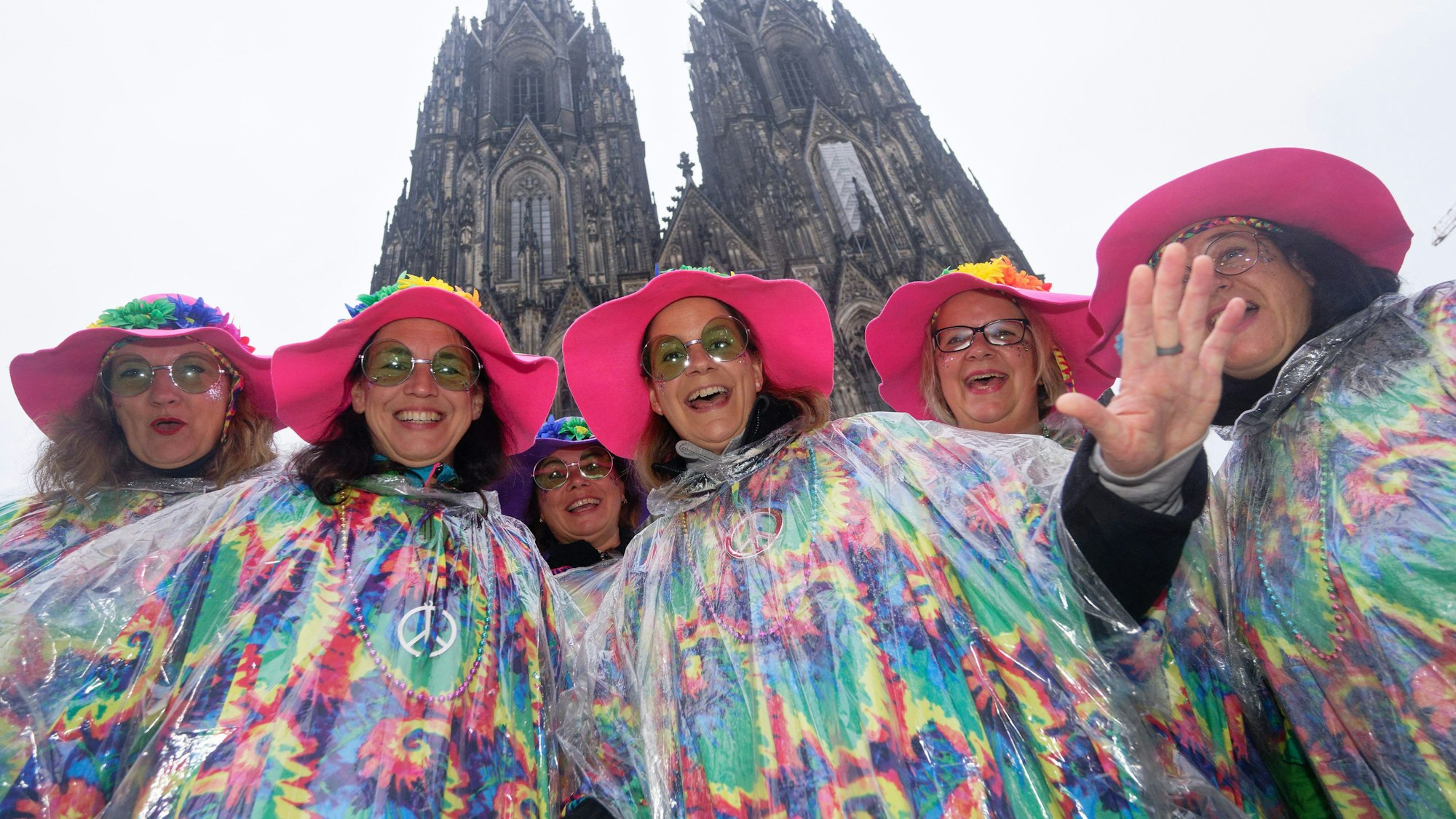 Im vergangenen Jahr brauchten diese Karnevalistinnen im Nieselregen vor dem Dom Regenkleidung. (Archivbild). Am 11.11.25 soll es zumindest ab Mittag trocken bleiben.