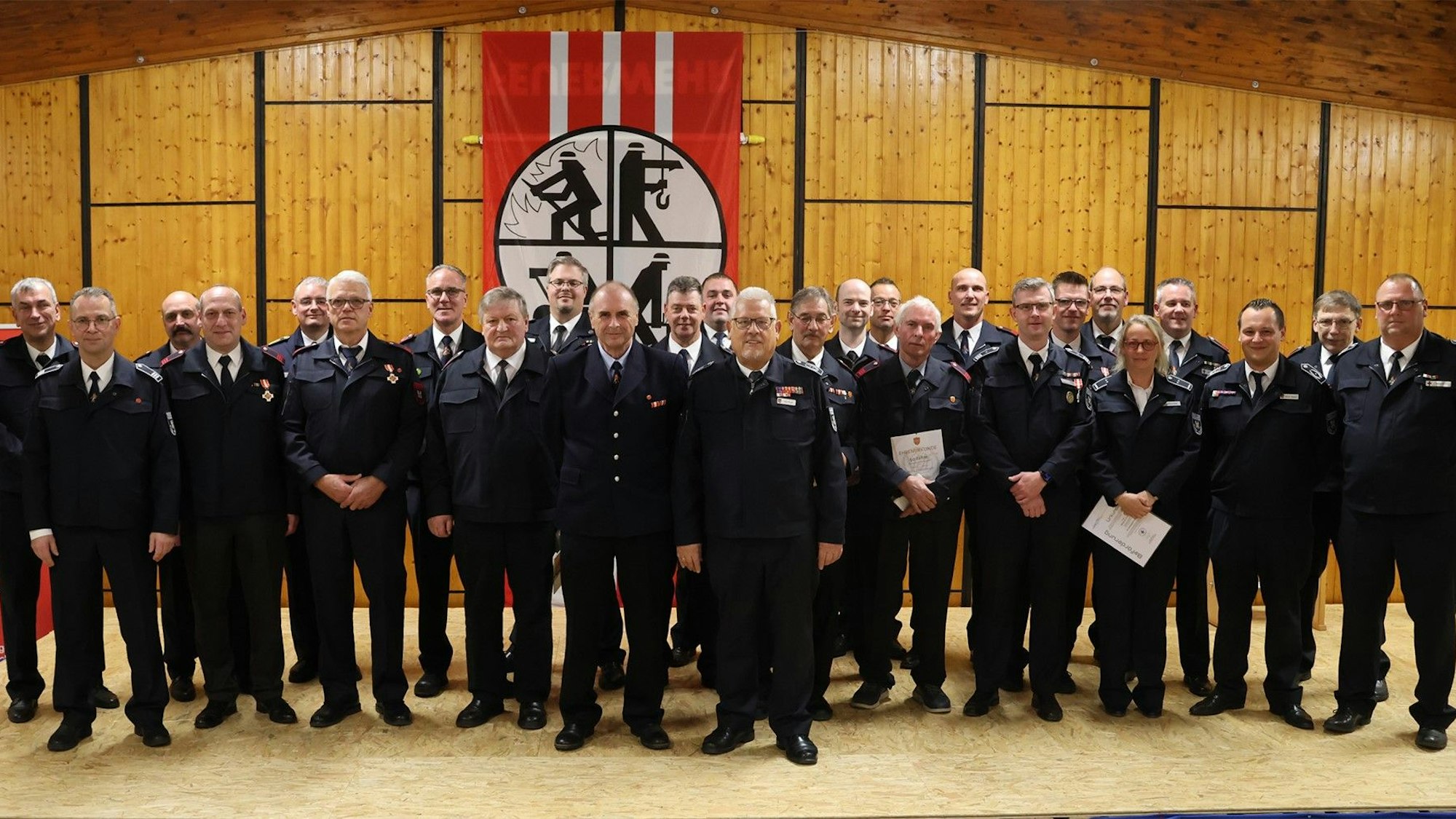 Eine Gruppe Feuerwehrleute steht in einer Halle.