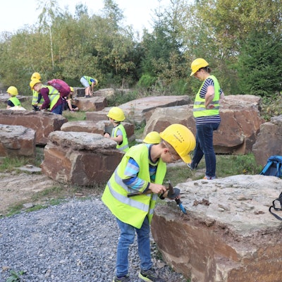 Fossiliensuche mit Hammer und Meißel in einem Lindlarer Grauwacke-Steinbruch.