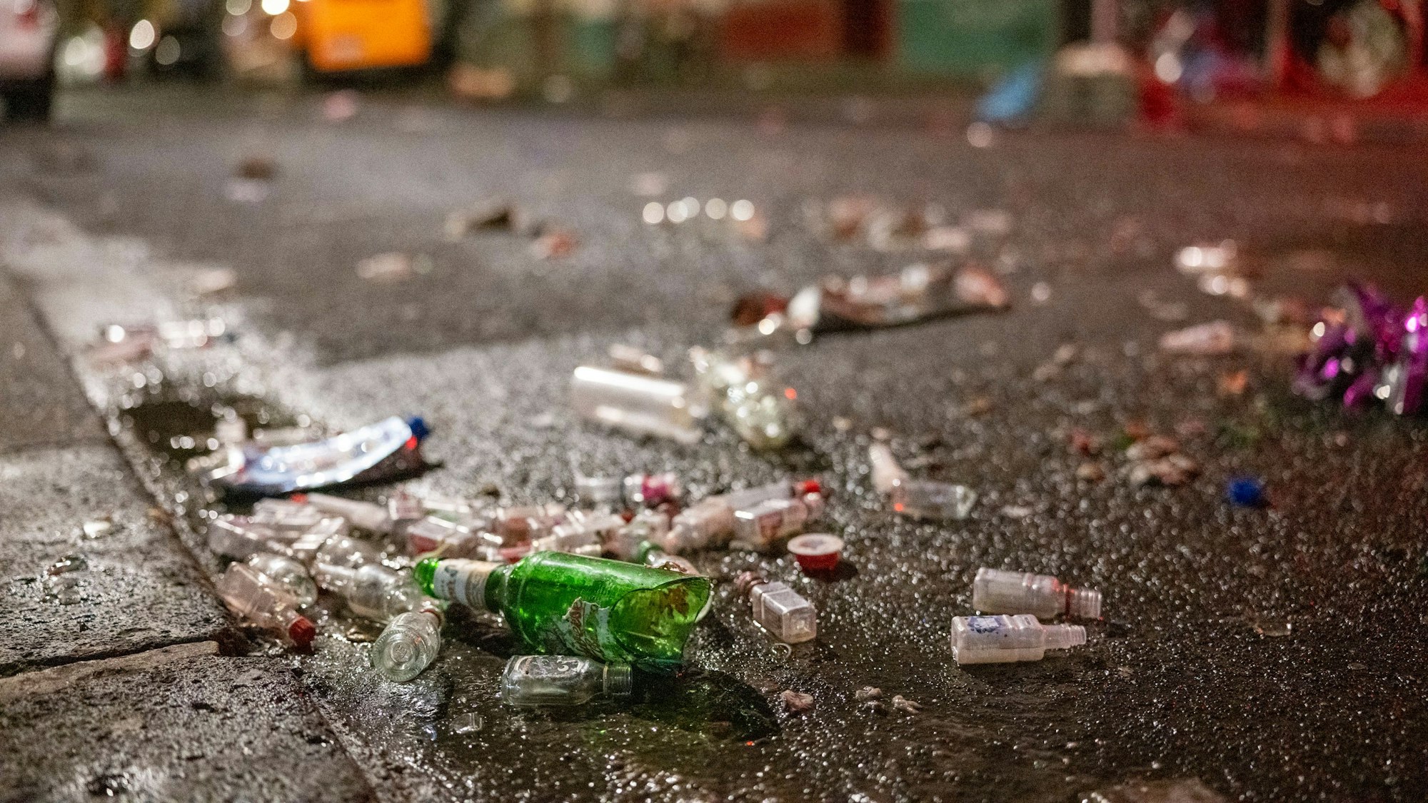 Leere Flaschen liegen auf der nassen Zülpicher Straße.