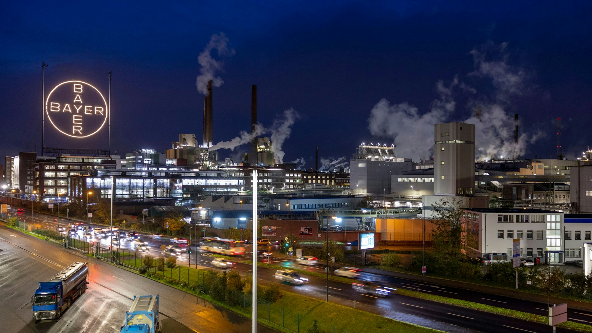 ARCHIV - 20.11.2023, Nrw, Köln: Das Bayer-Kreuz, das Logo des Unternehmens, leuchtet auf dem Werksgelände von Bayer in Leverkusen. Der Umbau des Agrarchemie- und Pharmakonzerns Bayer wird wohl viele Mitarbeiter den Job kosten. Im Zuge der geplanten Verschlankung der Verwaltung und der angestrebten Beschleunigung von Entscheidungsprozessen dürfte es zu einem erheblichen Personalabbau in Deutschland kommen, teilte das Unternehmen am Mittwochabend (17.01.2024) in Leverkusen mit. (zu dpa: «Milliardenverlust bei Bayer: Aktie fällt auf 20-Jahres-Tief») Foto: Thomas Banneyer/dpa +++ dpa-Bildfunk +++