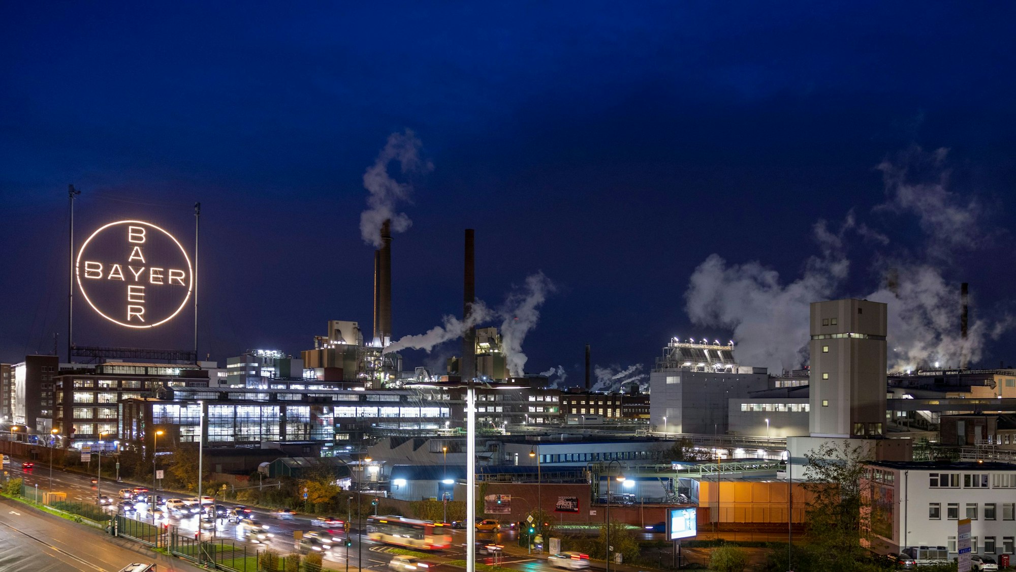 ARCHIV - 20.11.2023, Nrw, Köln: Das Bayer-Kreuz, das Logo des Unternehmens, leuchtet auf dem Werksgelände von Bayer in Leverkusen. Der Umbau des Agrarchemie- und Pharmakonzerns Bayer wird wohl viele Mitarbeiter den Job kosten. Im Zuge der geplanten Verschlankung der Verwaltung und der angestrebten Beschleunigung von Entscheidungsprozessen dürfte es zu einem erheblichen Personalabbau in Deutschland kommen, teilte das Unternehmen am Mittwochabend (17.01.2024) in Leverkusen mit. (zu dpa: «Milliardenverlust bei Bayer: Aktie fällt auf 20-Jahres-Tief») Foto: Thomas Banneyer/dpa +++ dpa-Bildfunk +++