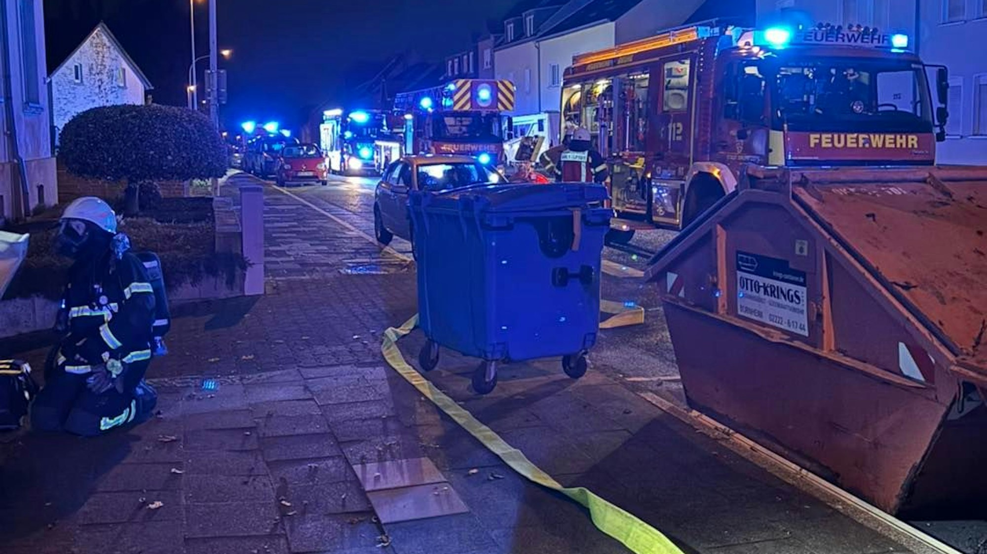 Auf dem Foto sind Einsatzfahrzeuge der Feuerwehr vor dem Brandhaus zu sehen.
