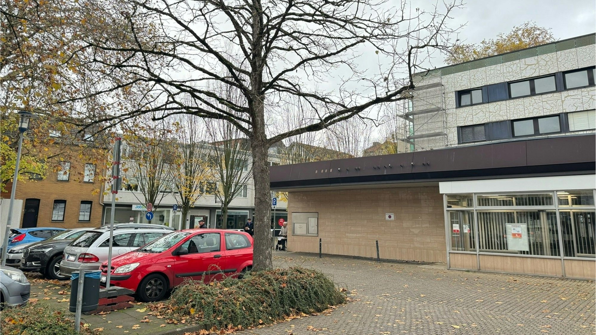 Auf dem Bild sind geparkte Autos und ein Geschäftshaus in der Frechener Innenstadt zu sehen.