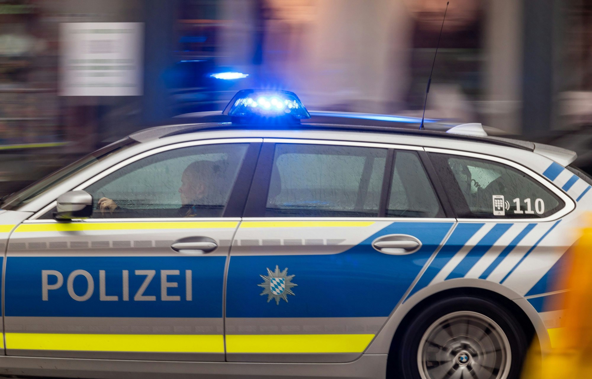 Ein Polizeiwagen fährt mit Blaulicht zu einem Einsatz. (