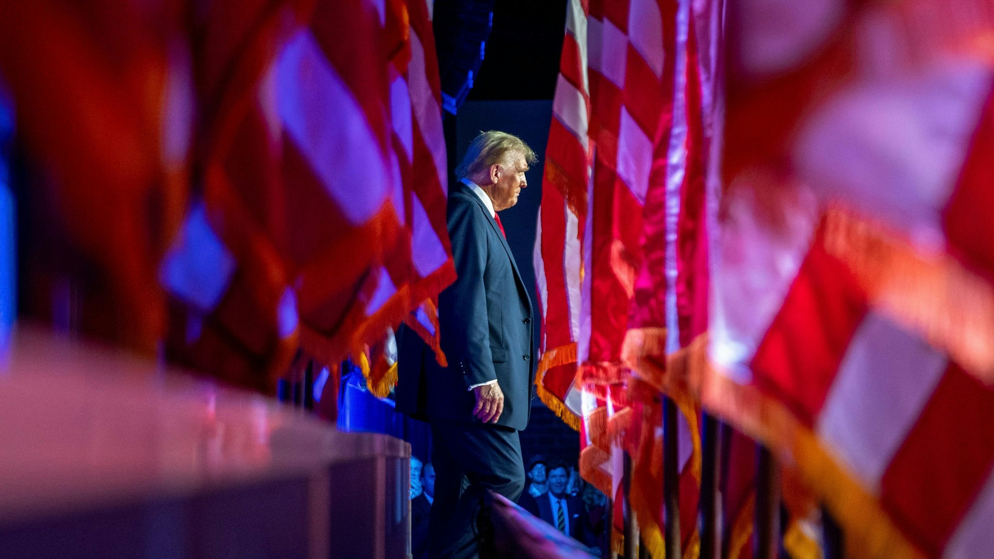 Donald Trump läuft einen Spalier aus US-Flaggen entlang.