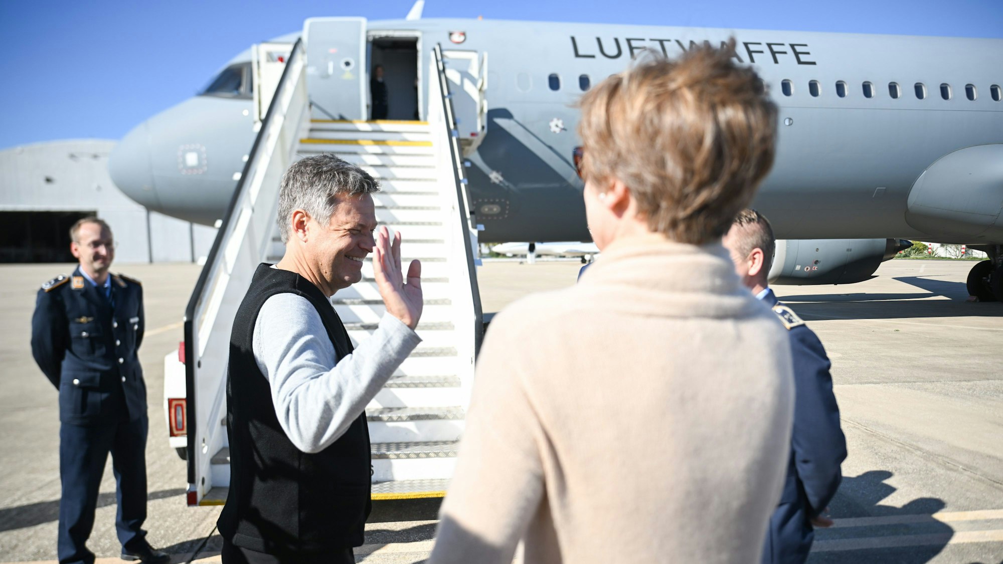 Robert Habeck, Bundesminister für Wirtschaft und Klimaschutz, winkt vor seiner Abreise vor der Ersatzmaschine zum Abschied.
