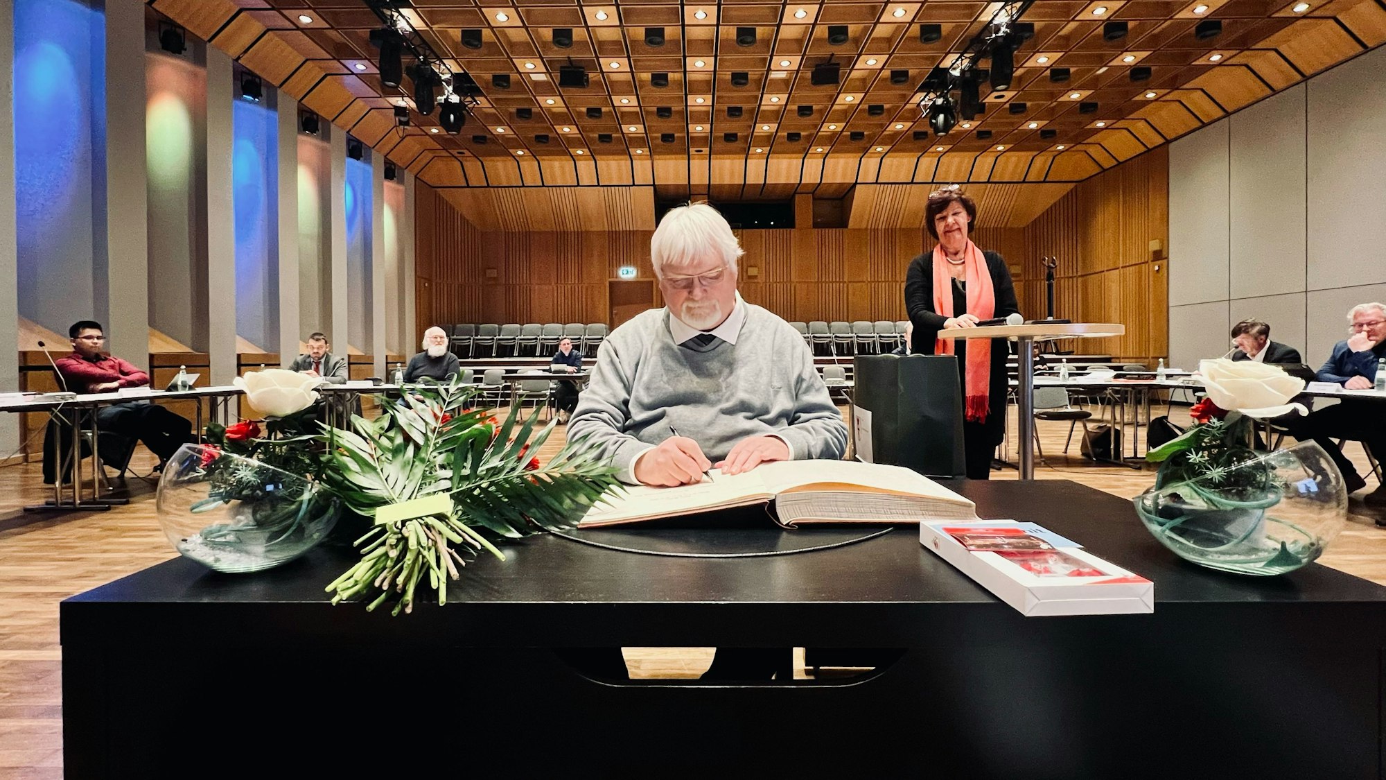 25 Jahre Mitglied der Bezirksvertretung: Dieter Redlin, Vorsitzender der Fraktion der Grünen in der Bezirksvertretung Porz, trägt sich in das Ehrenbuch des Stadtbezirks ein.