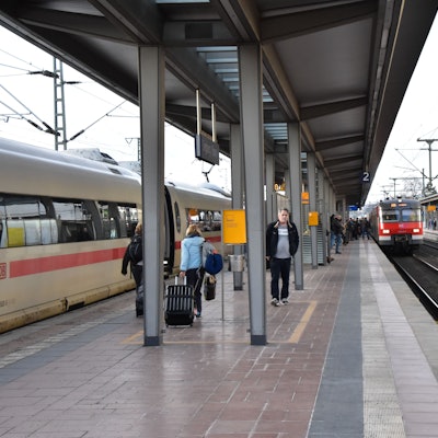 Ein Regionalzug fährt in den Siegburger Bahnhof auf Gleis 2 ein, einige Menschen stehen am Gleis.
