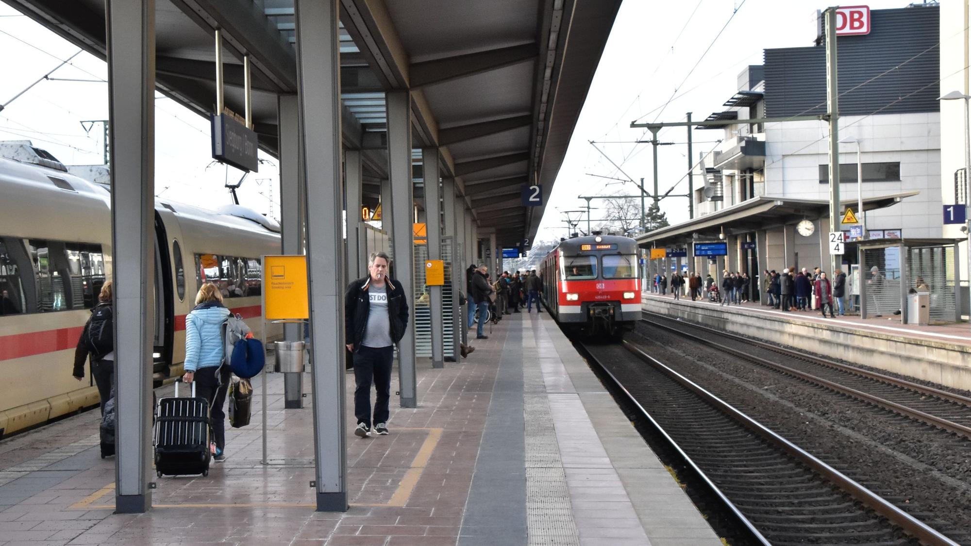 Ein Regionalzug fährt in den Siegburger Bahnhof auf Gleis 2 ein, einige Menschen stehen am Gleis.