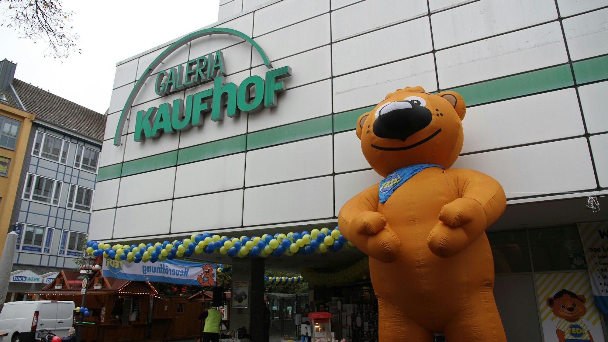 Eine bärenförmige Werbefigur vor einem Warenhaus