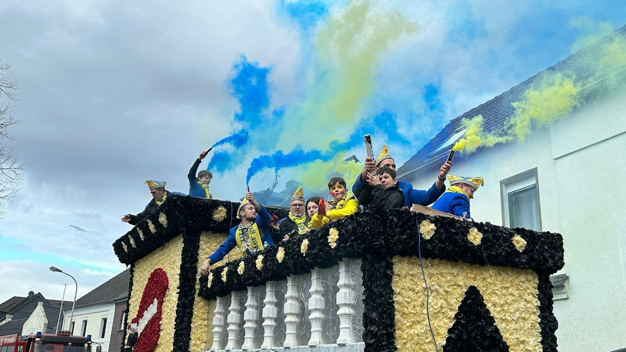 Die jungen Vereinsmitglieder des KG Vernich zünden auf einem Karnevalswagen Leuchtfeuer.