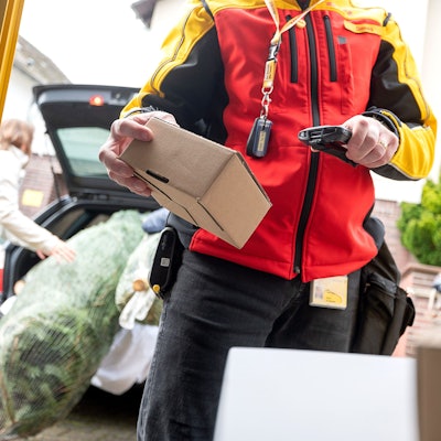 Ein Paketzusteller scannt ein Päckchen.