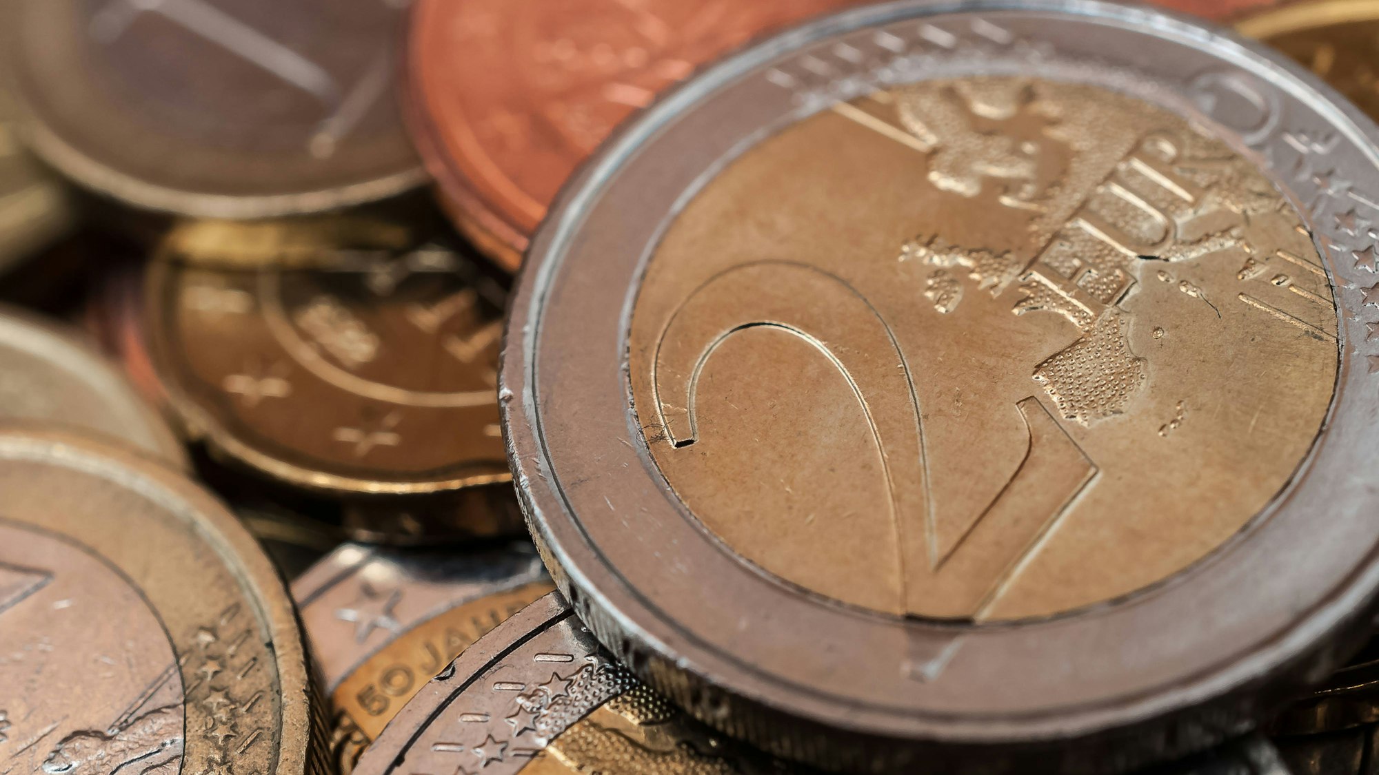 Eine 2-Euro-Münze auf anderen Geldmünzen.