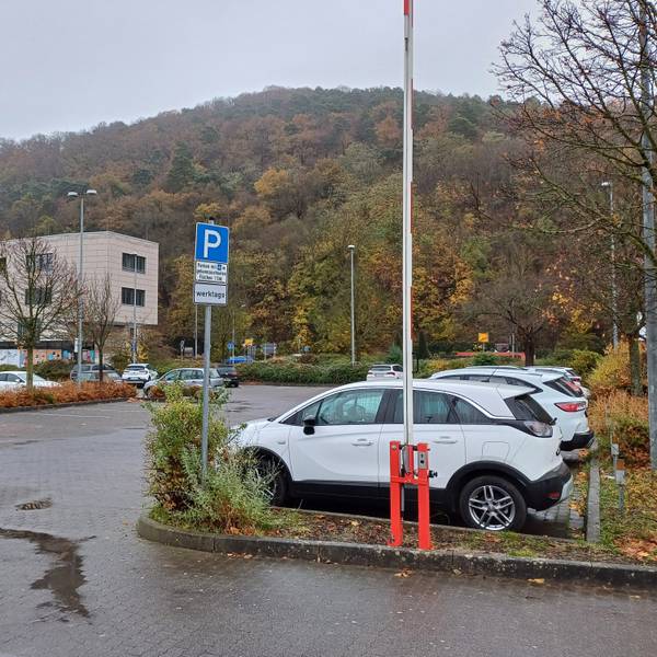 Das Foto zeigt den südlichen Teil des Aldi-Parkplatzes, auf dem Autos parken. Im Hintergrund ist ein Teil eines Gebäudes des City-Outlets zu erkennen.
