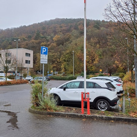 Das Foto zeigt den südlichen Teil des Aldi-Parkplatzes, auf dem Autos parken. Im Hintergrund ist ein Teil eines Gebäudes des City-Outlets zu erkennen.