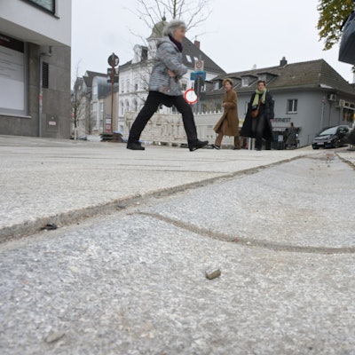 Zu sehen sind die scharfkantigen Versprünge zwischen Regenrinne und Bodenbelag.