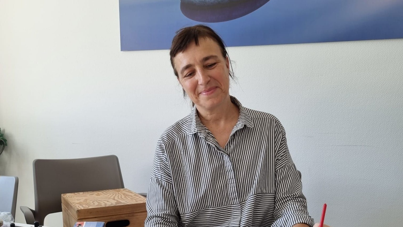 Frau beobachtet, wie andere Person etwas mit einem Pinsel malt.