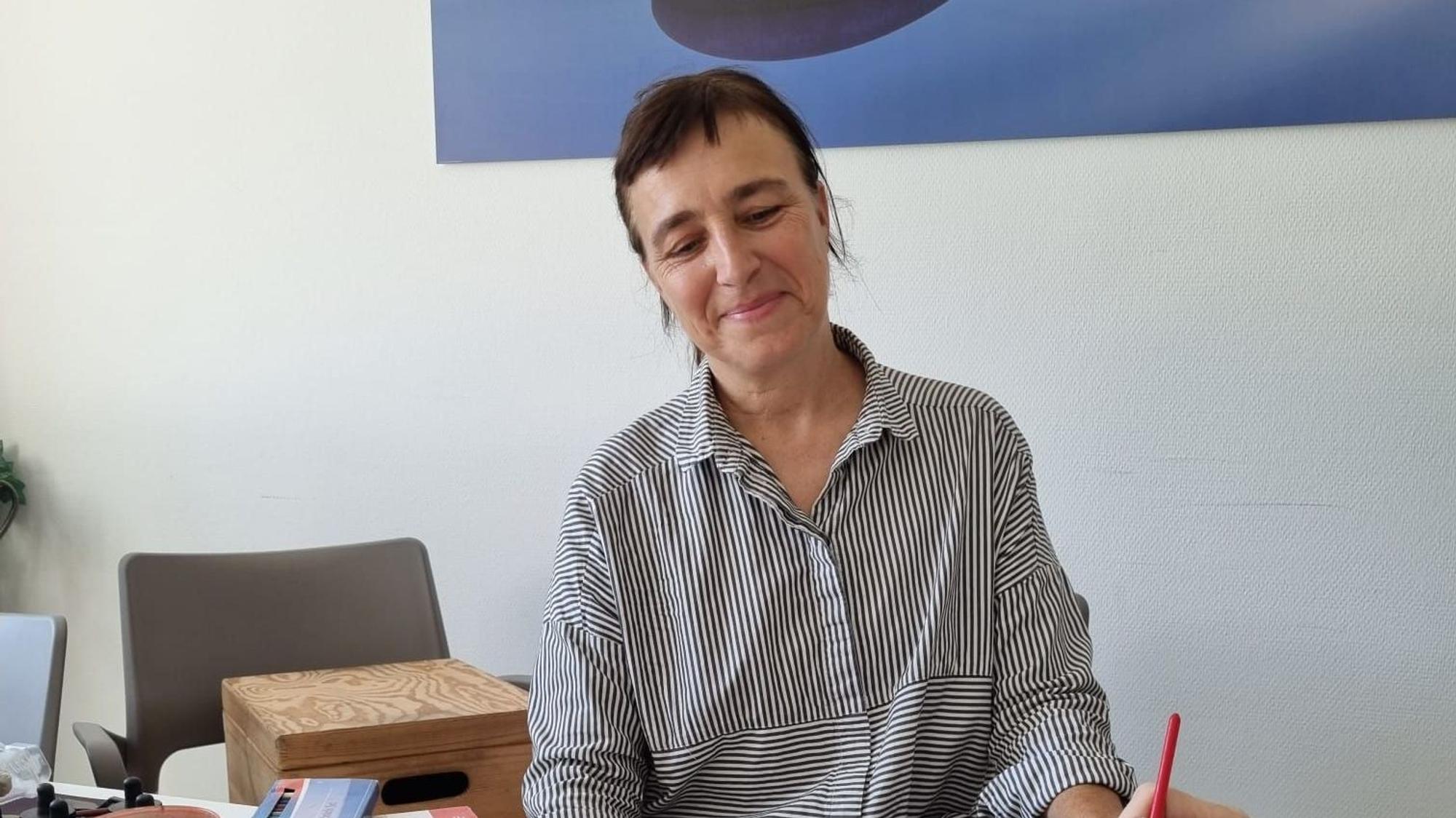 Frau beobachtet, wie andere Person etwas mit einem Pinsel malt.