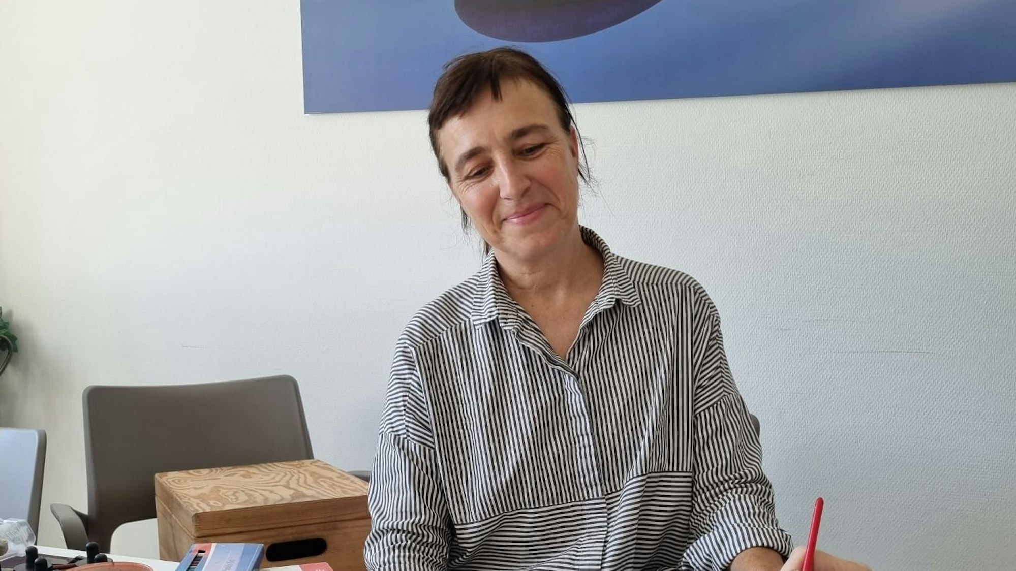 Frau beobachtet, wie andere Person etwas mit einem Pinsel malt.