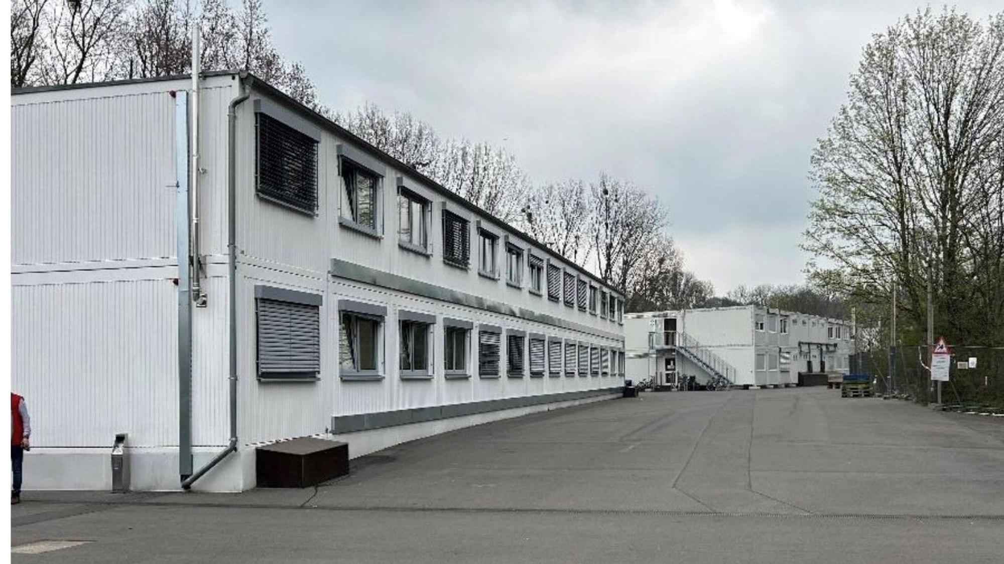 Auf dem Foto sind weiße Container-Wohnungen einer Unterkunft für Geflüchtete zu sehen.