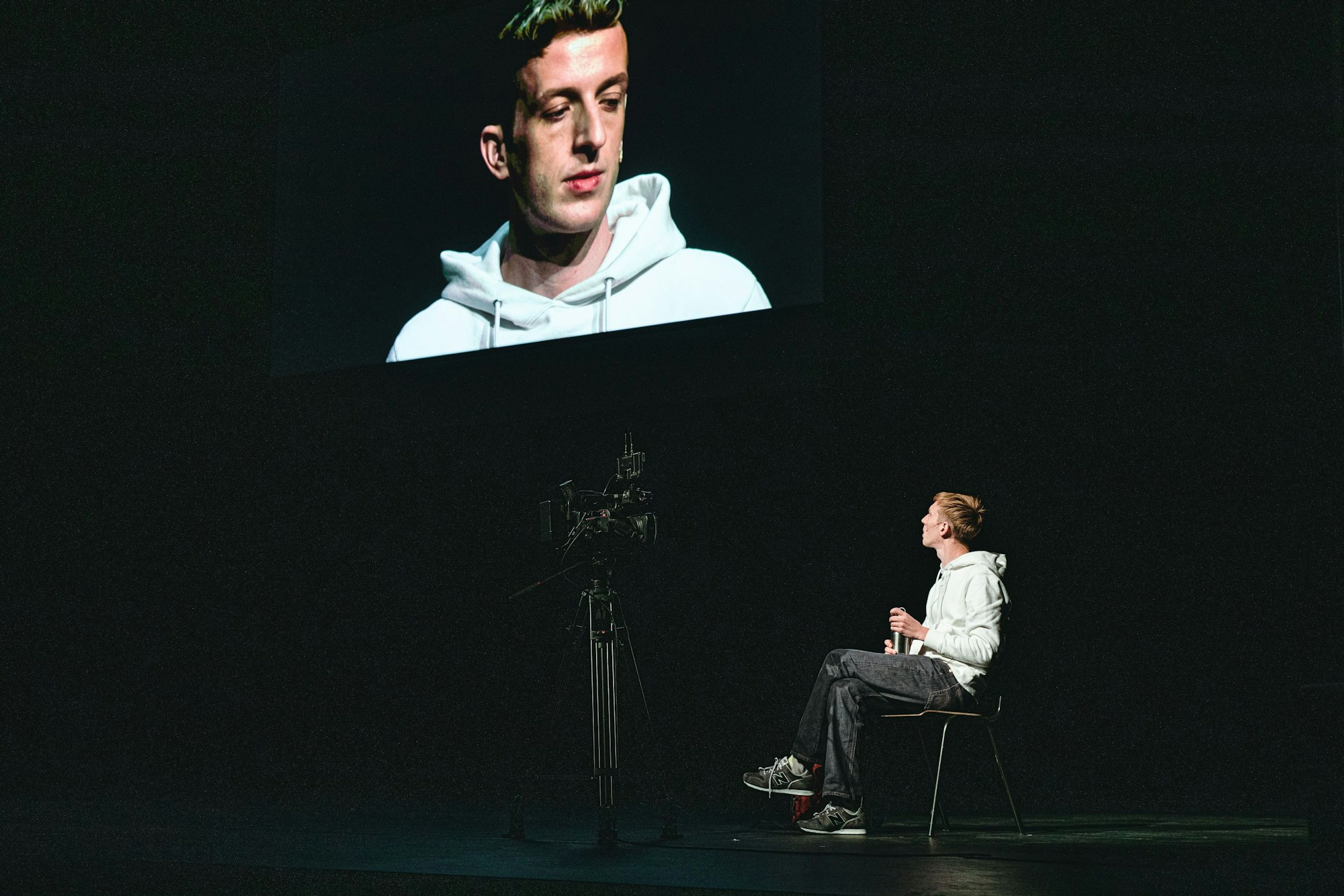 Szene aus Milo Raus Stück "The Interrogation"
Auf der Leinwand: Édouard Louis, auf der Bühne: Arne De Tremerie
