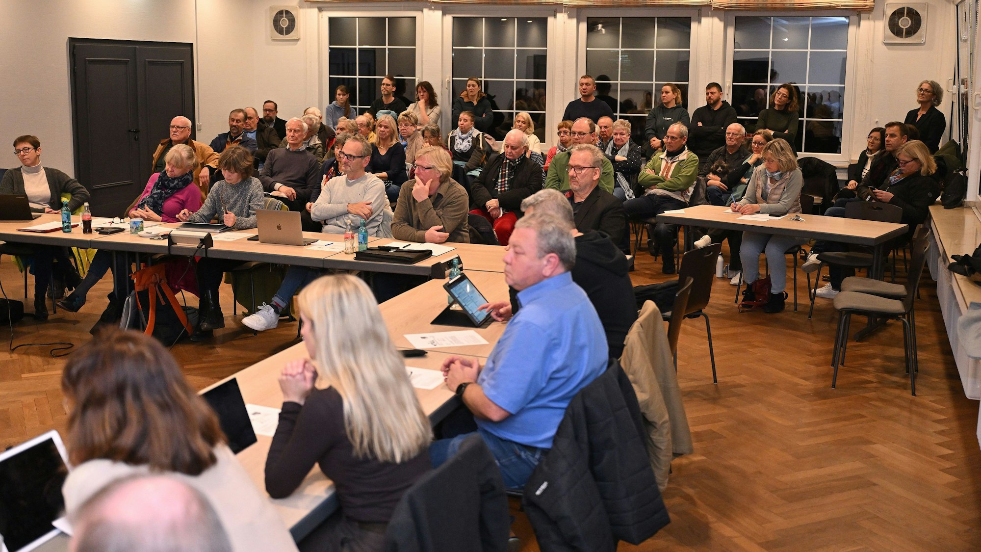 In einem Sitzungssaal sitzen Politiker und Politikerinnen an Tischen, dahinter viele Zuschauer.