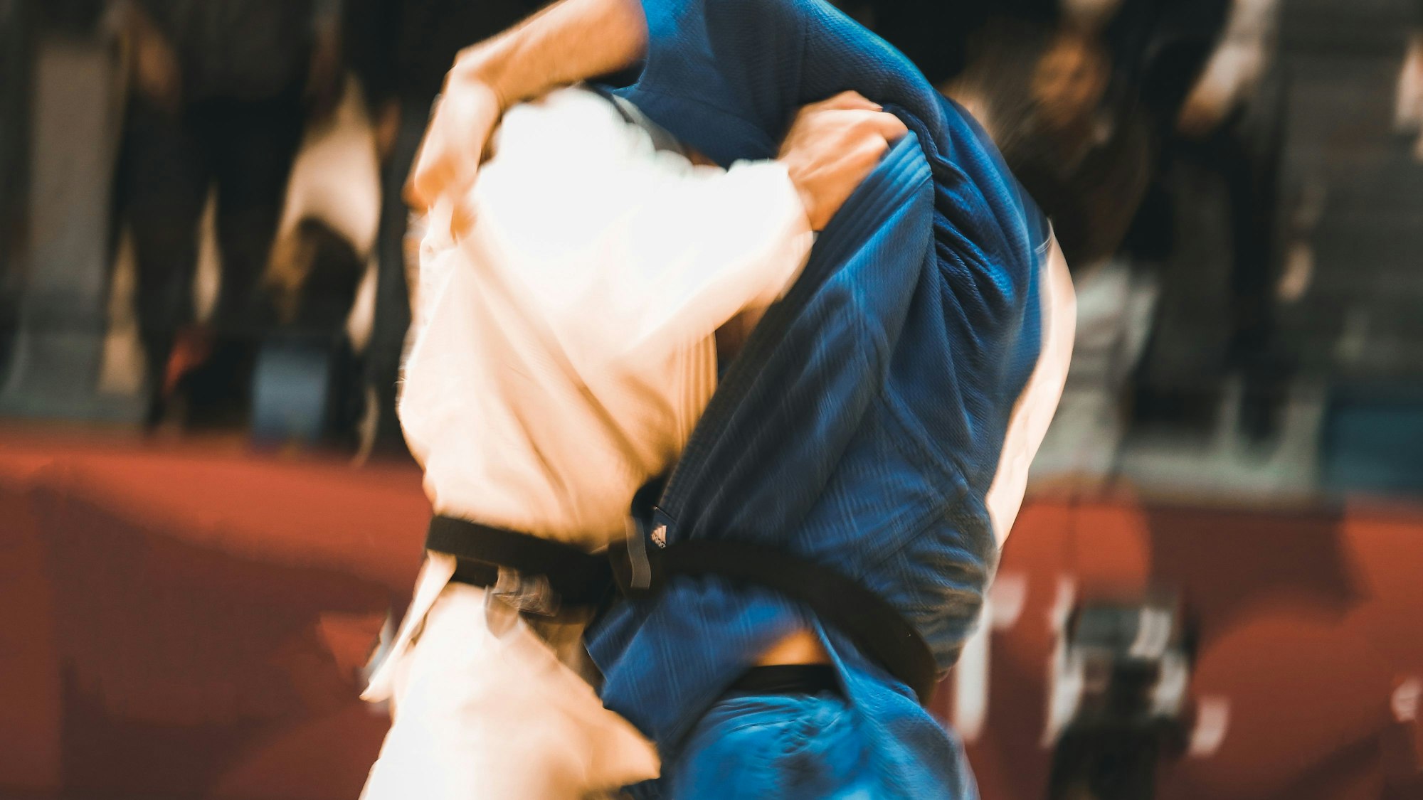 Zwei Judoka in einer verkeilten Position, das Bild ist verschwommen.