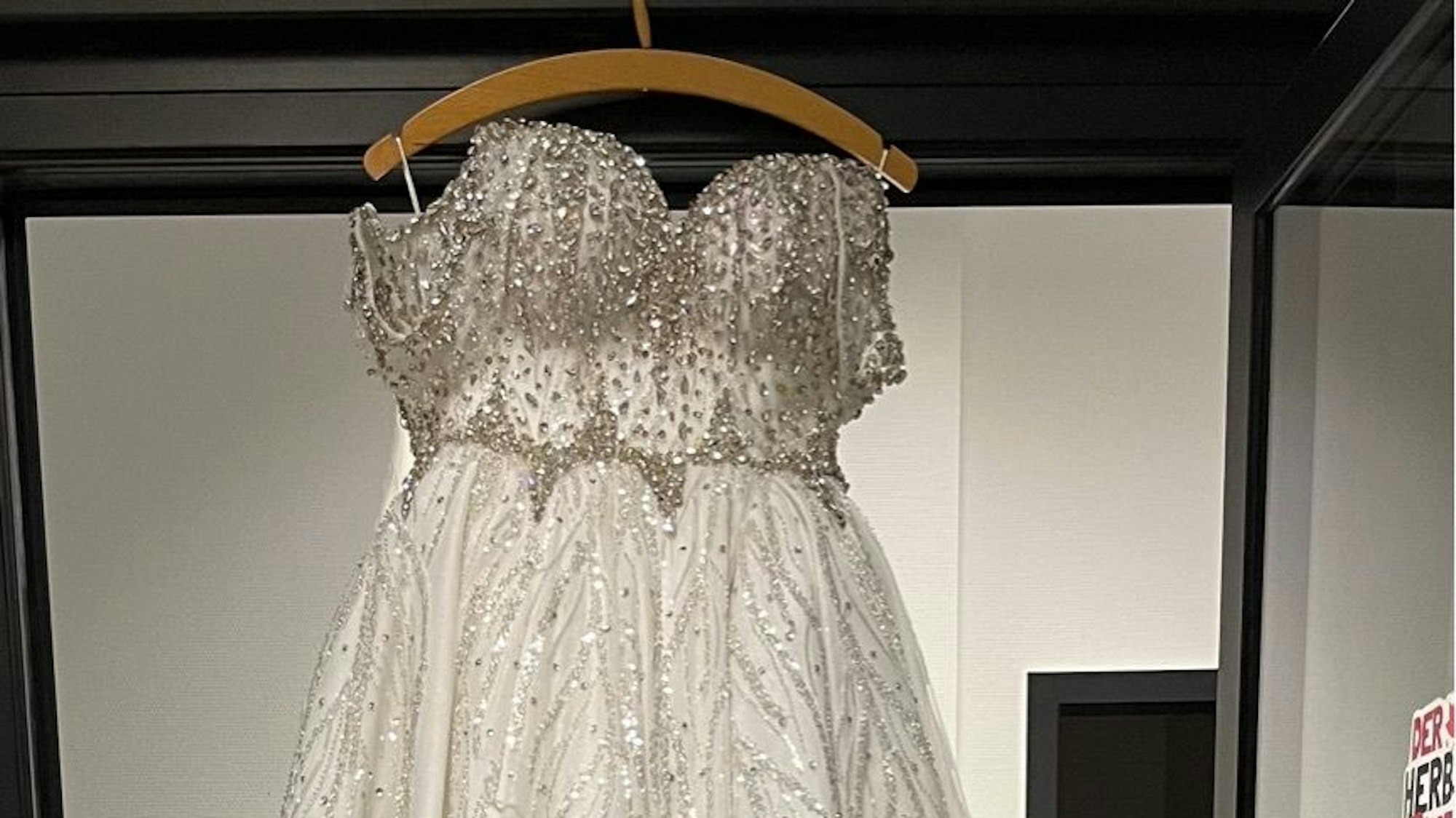 Auf einem Bügel hängt ein Brautkleid.