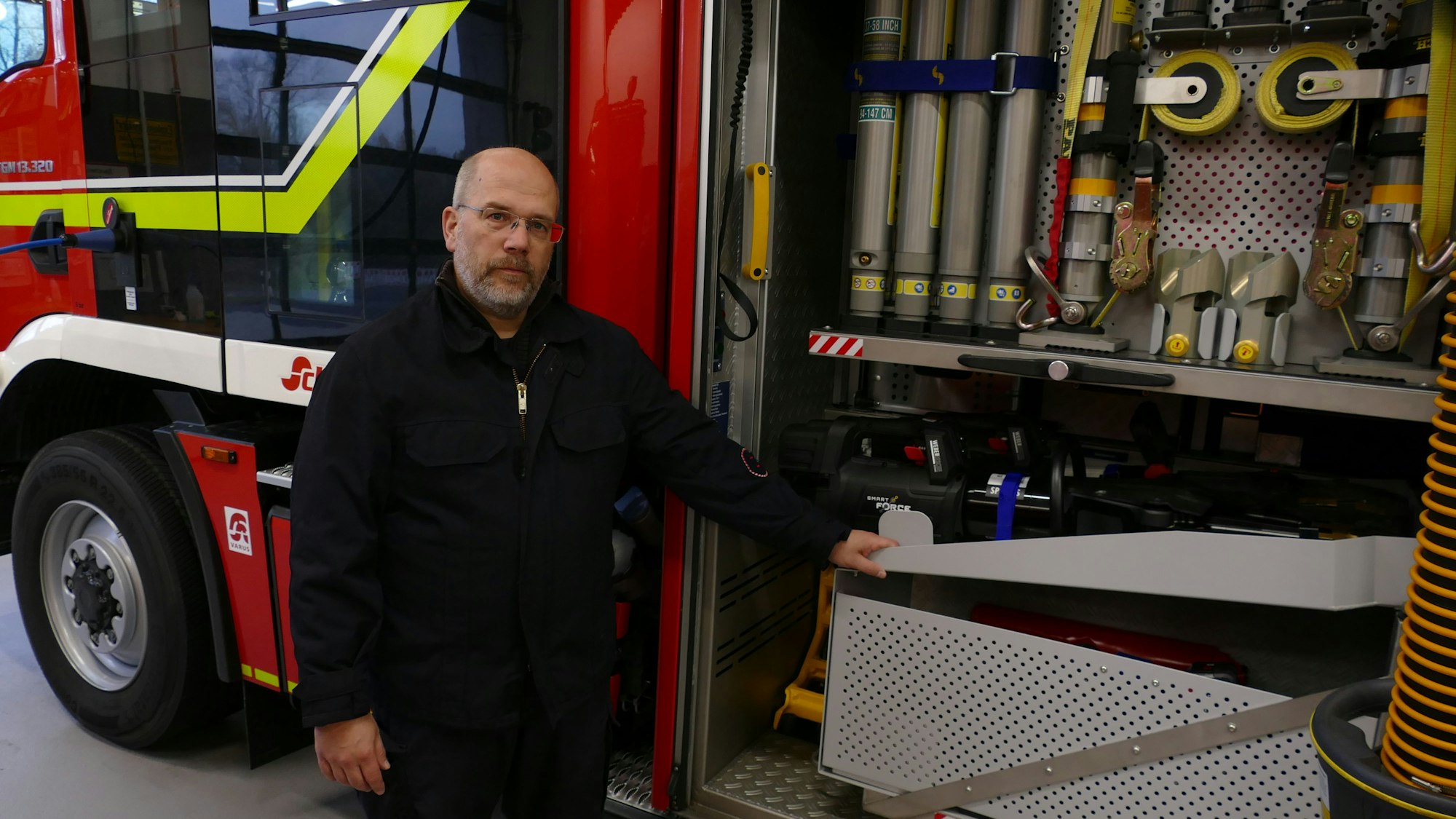 Ein Feuerwehrmann steht an einem Fahrzeug.