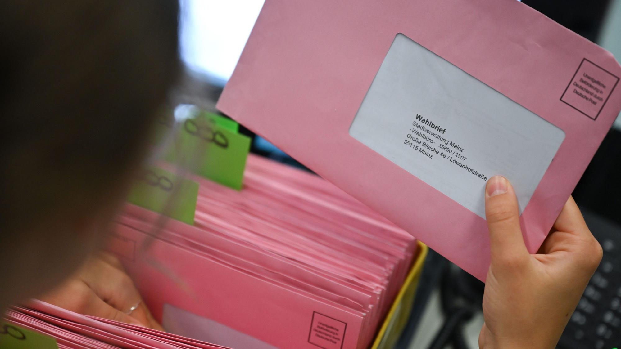Rote Umschläge mit Wahlunterlagen werden in einem Briefwahlbüro nach den Nummern der Wahlbüros sortiert.