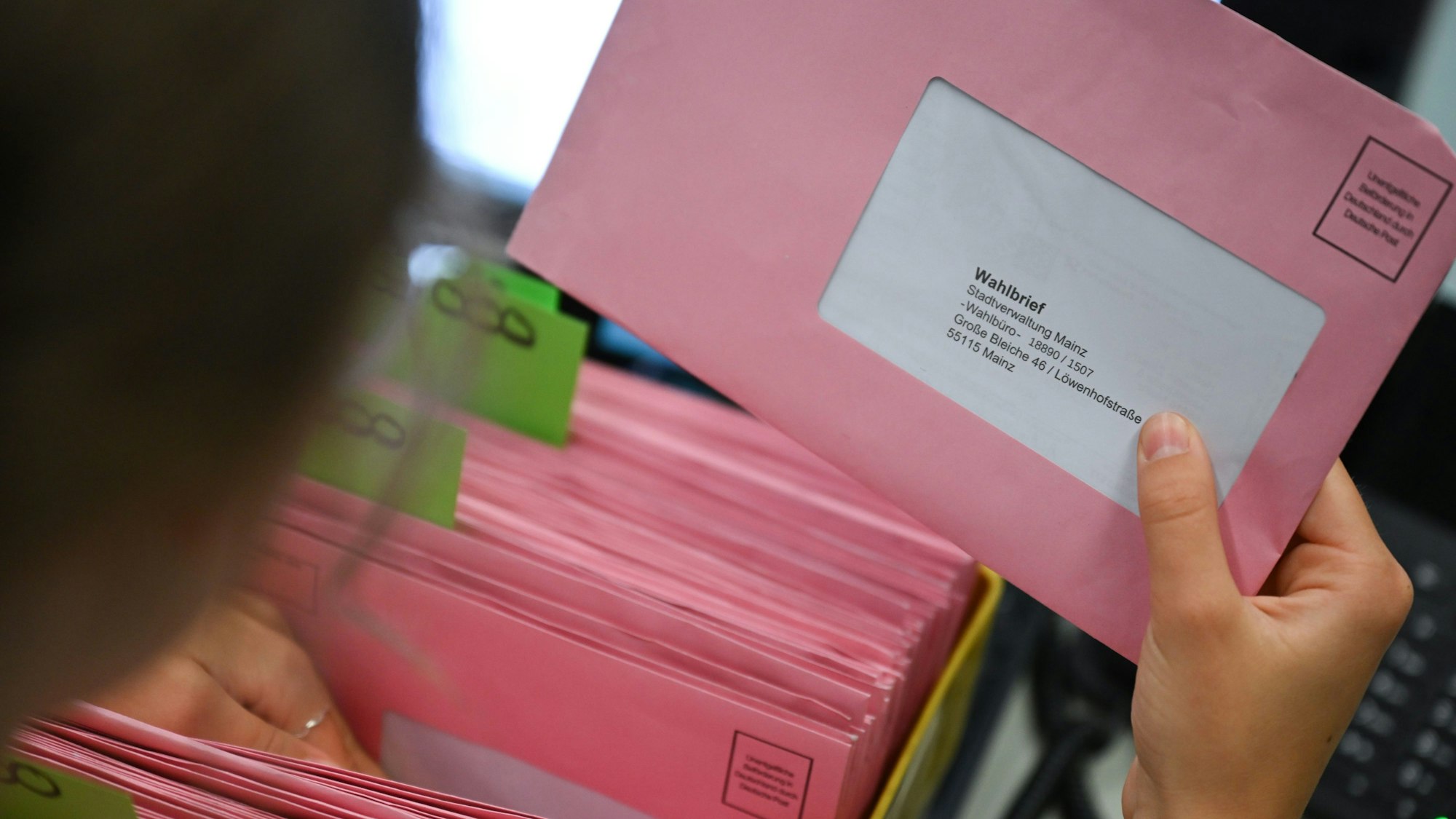 Rote Umschläge mit Wahlunterlagen werden in einem Briefwahlbüro nach den Nummern der Wahlbüros sortiert.