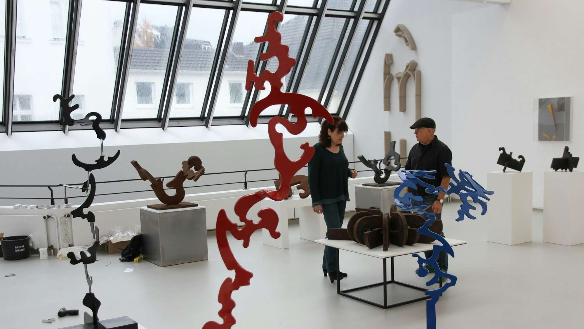 Eine Frau und ein Mann inmitten stählerner Skulpturen