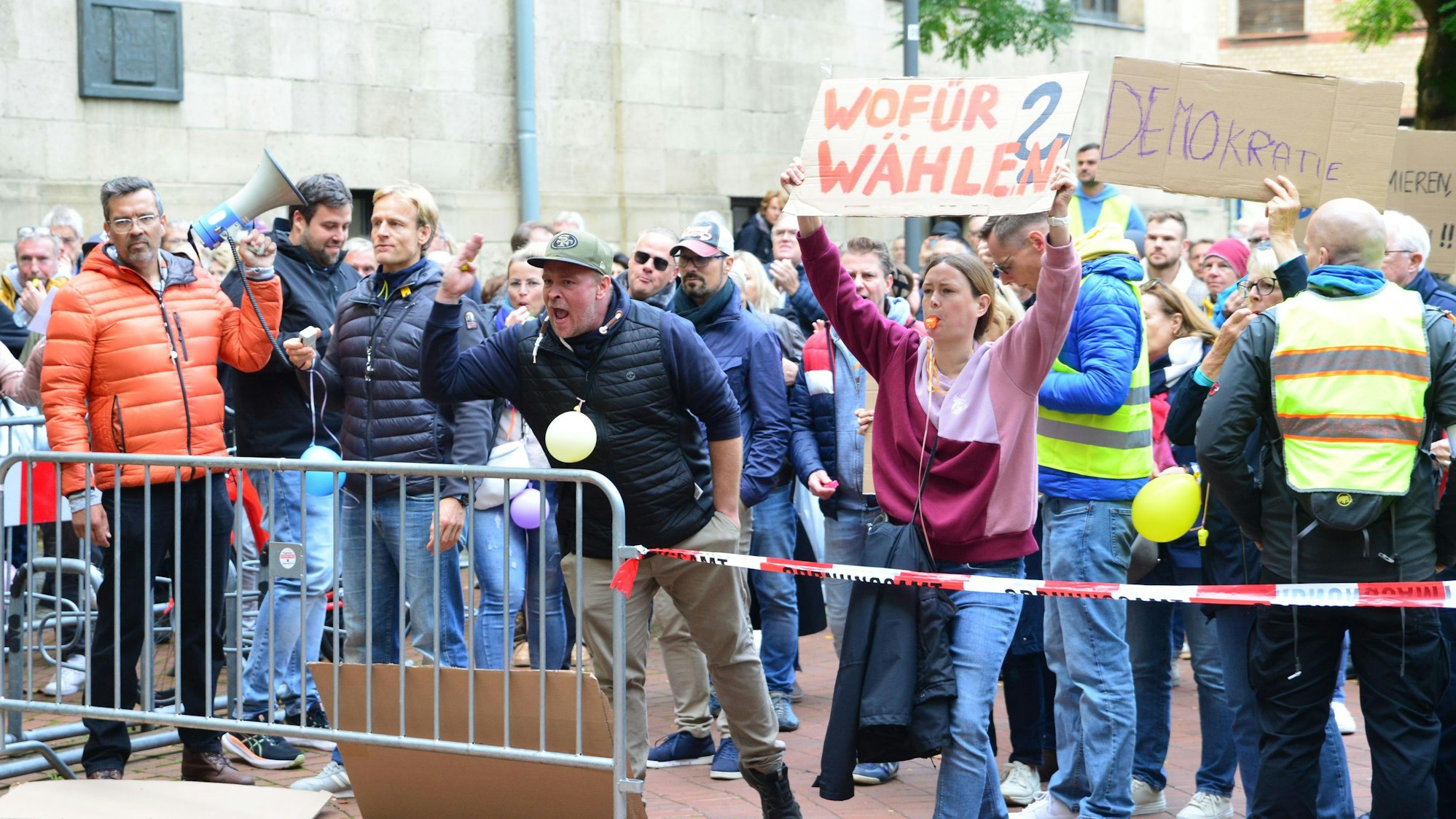 Auf dem Foto sind Bürgerinnen und Bürger zu sehen, die gegen die Entscheidung protestieren, in Frechen-Königsdorf eine ZUE einzurichten. Sie fühlen sich übergangen.