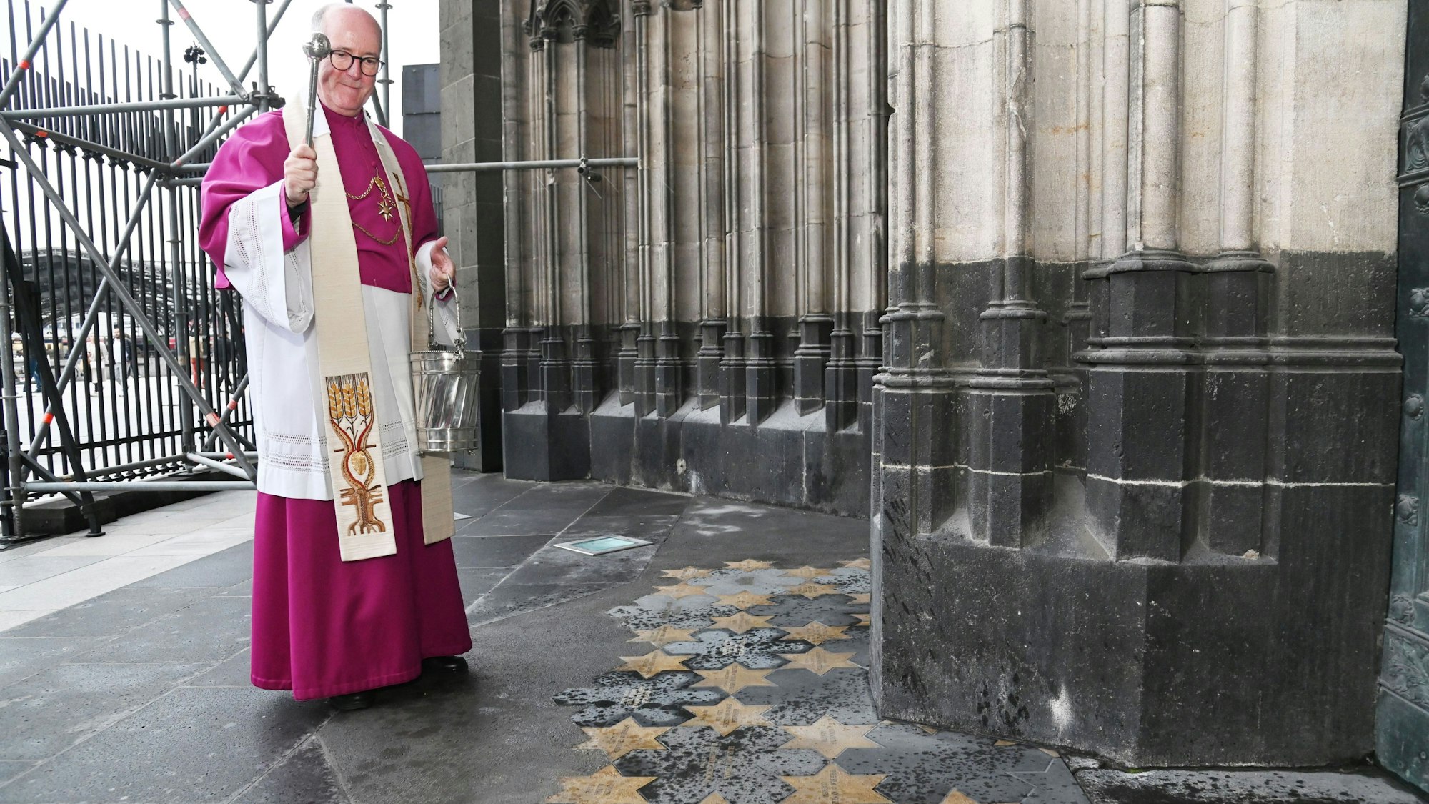 Dompropst Guido Assmann segnet 24 neue Sterne vor dem Michaelsportal.