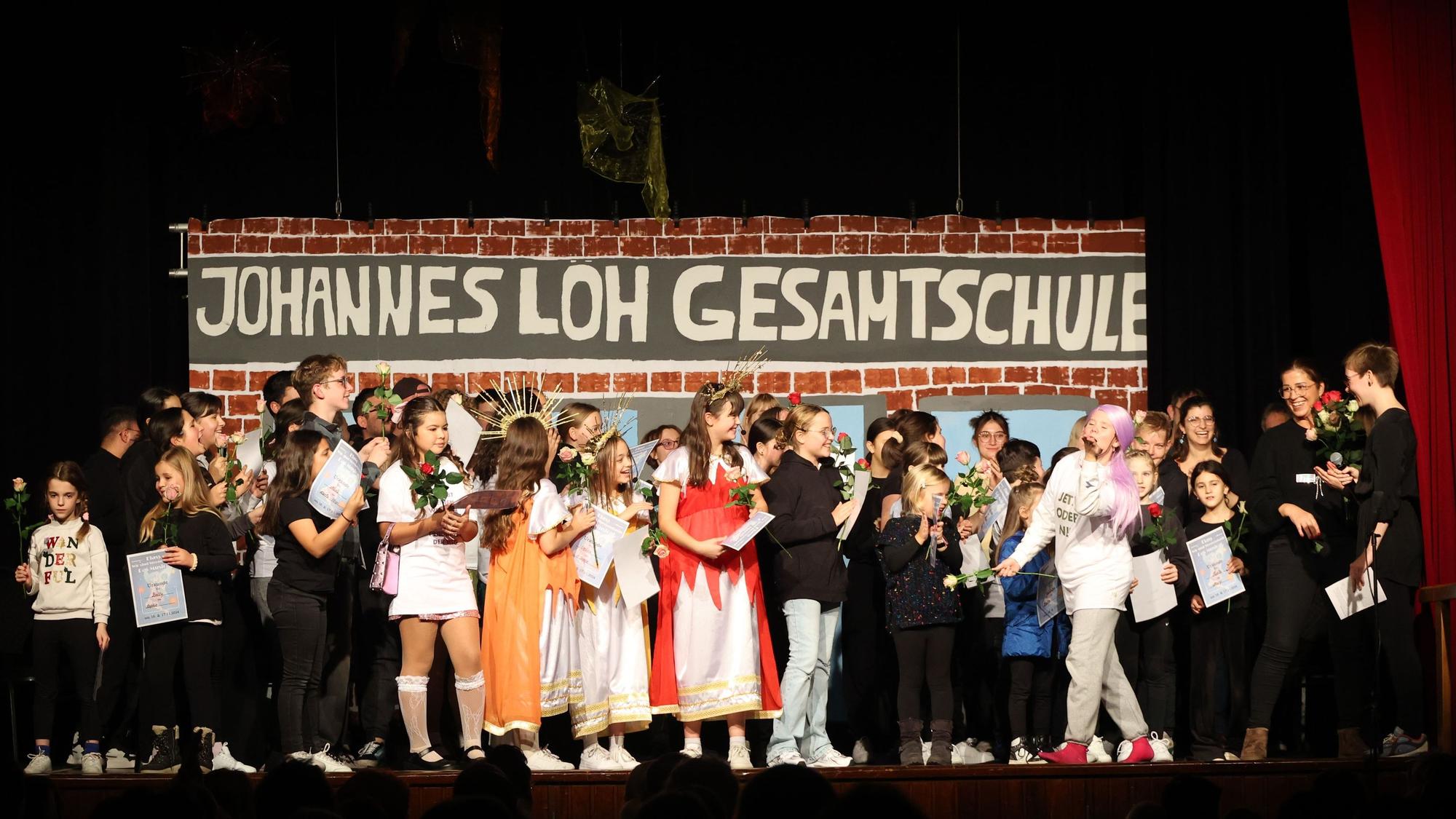 Kinder und Erwachsene stehen auf einer Bühne.