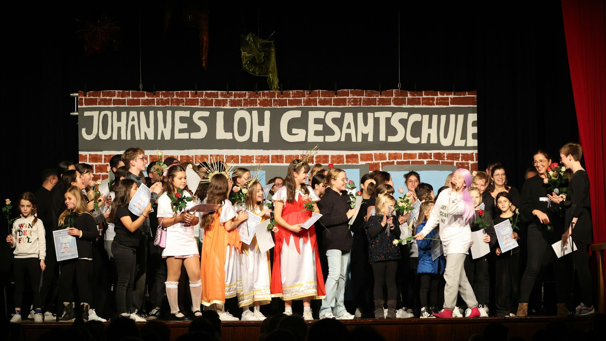 Kinder und Erwachsene stehen auf einer Bühne.