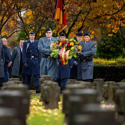 Das Bild zeigt die Prozession auf dem Weg zum Ehrenfriedhof.