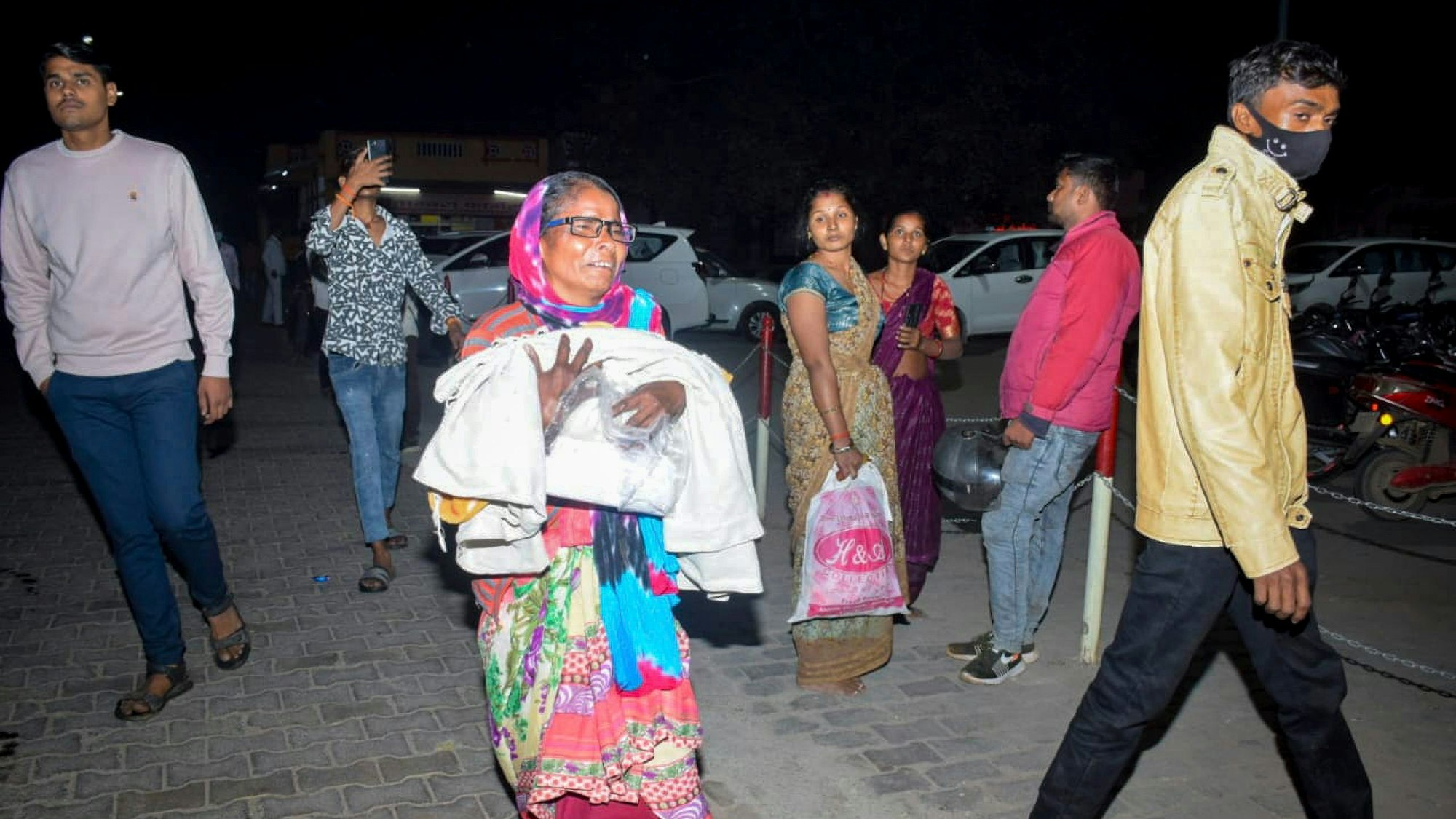 A woman rushes a child to the emergency ward after a fire broke out in a neonatal intensive care unit at Jhansi Medical College hospital in Jhansi, India, Friday, Nov. 15, 2024. (AP Photo)