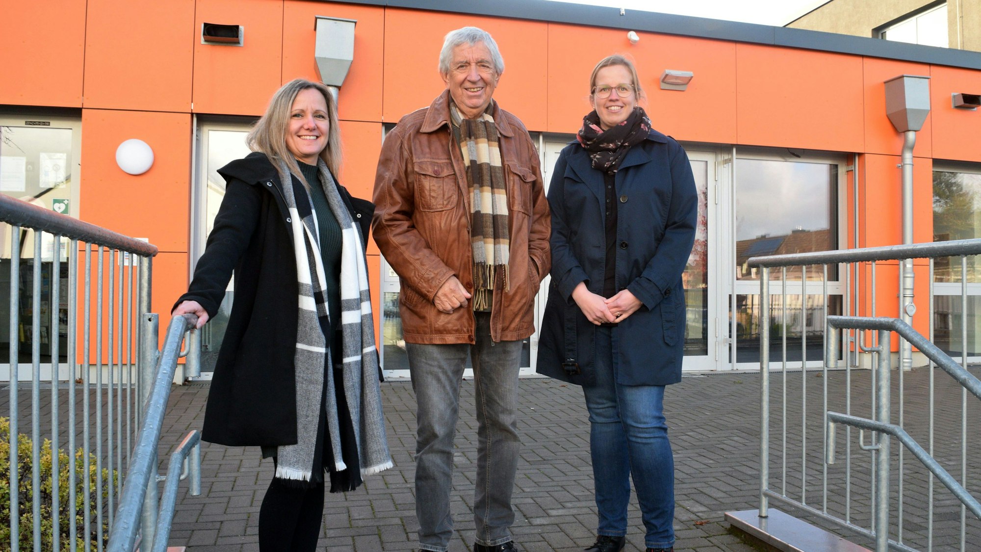 Zwei Frauen und ein Mann stehen nebeneinander.