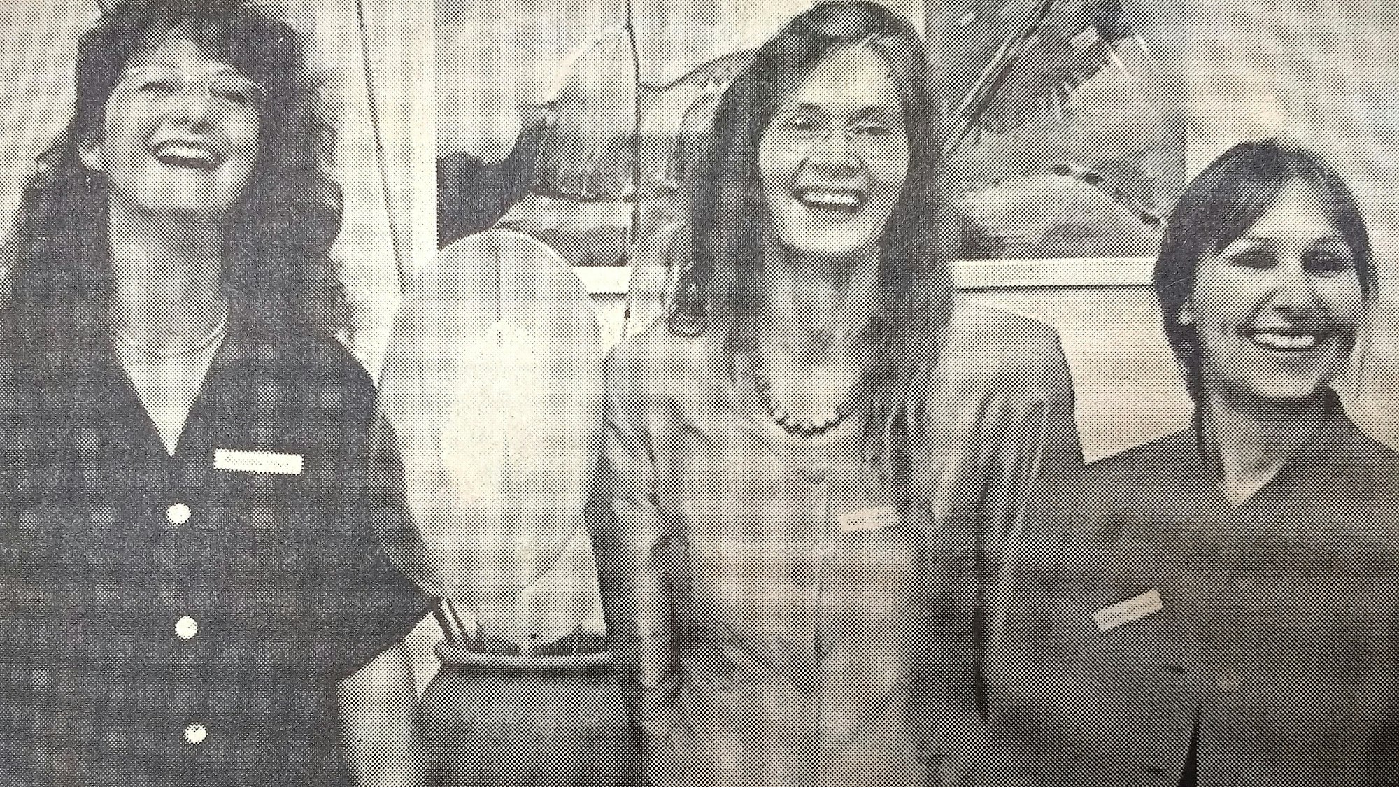 Ein alter Zeitungsausschnitt, auf dem die drei Beraterinnen zu sehen sind. Zwischen ihnen steht eine Vase, in der aufgeblasene Kondome wie Blumen stehen.