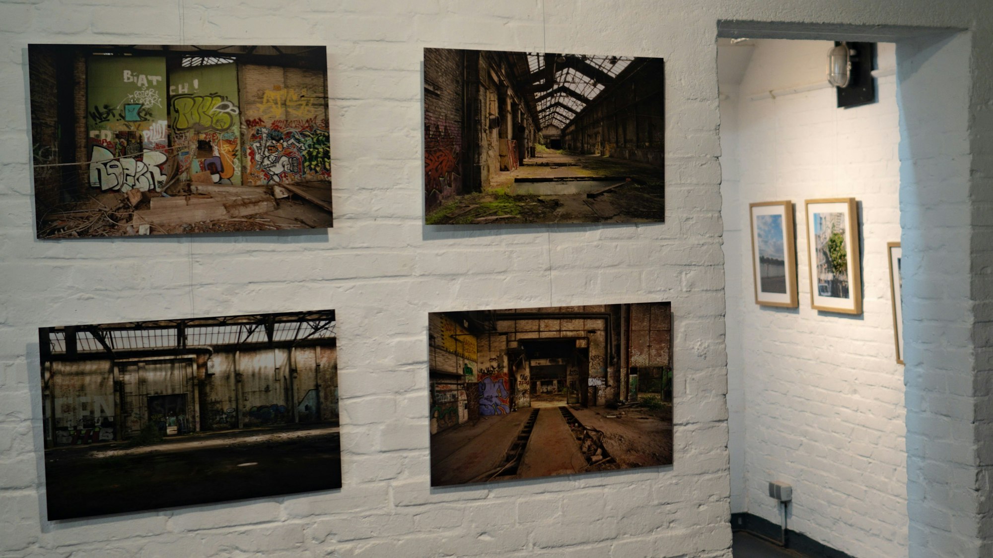 Fotografien der Ausstellung „Bezirk9 – Urbanes Leben in Köln-Mülheim“ hängen im Kulturbunker an der Wand.