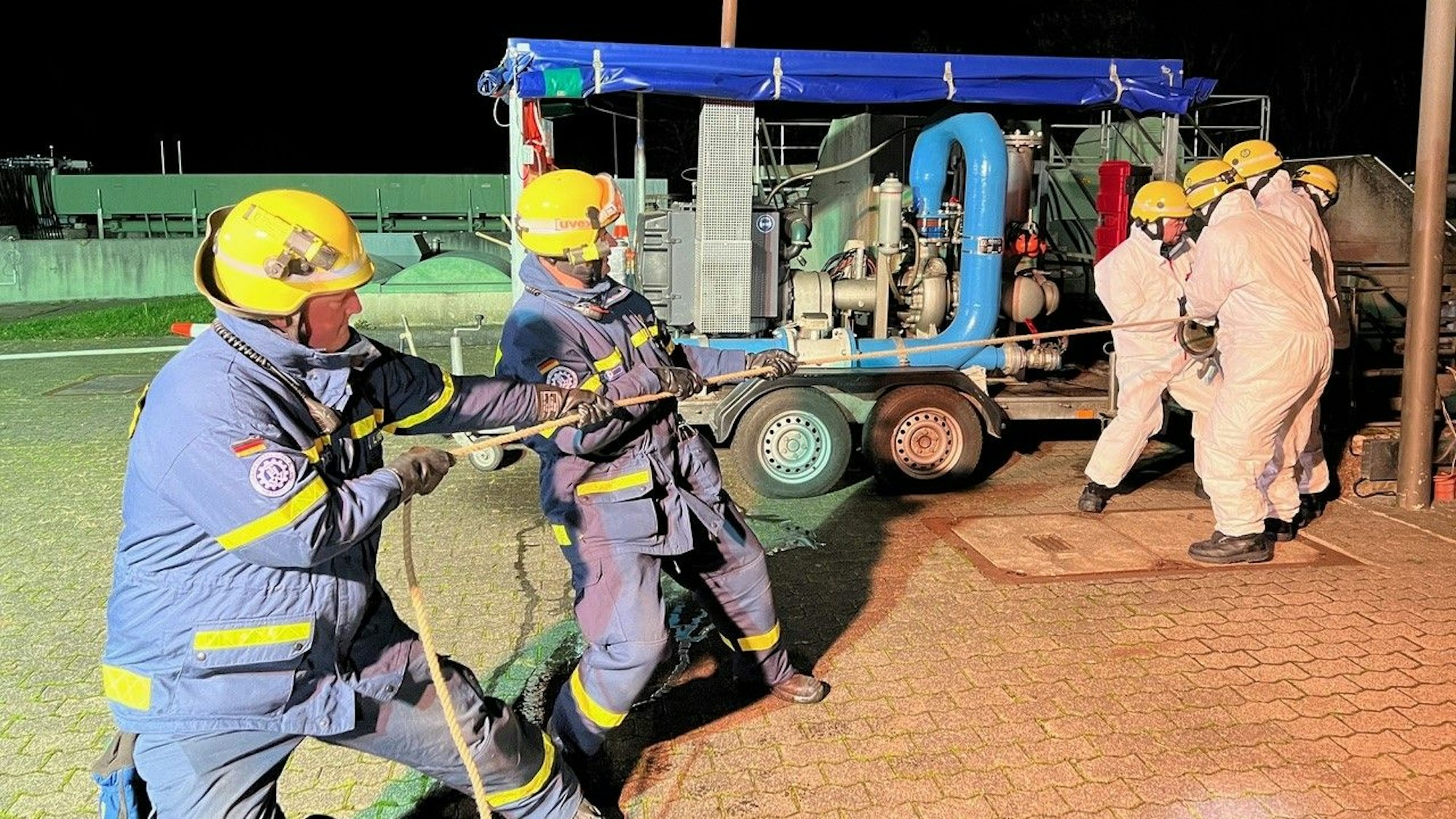 Das Bild zeigt sechs Mitarbeitende des THW, die mit vereinten Kräften an einem Seil ziehen.