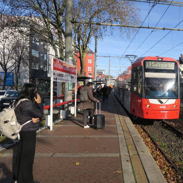An einer Haltestelle der Straßenbahn fährt ein Zug der Linie 13 ein.
