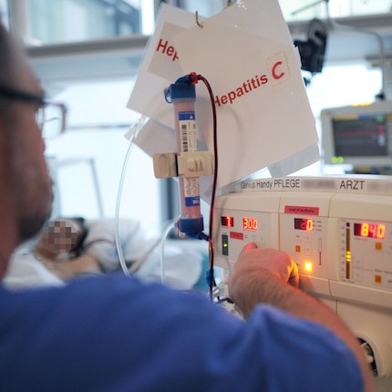 Ein Pfleger kümmert sich in einem Klinikum auf der Intensivstation um einen Patienten mit Hepatitis C.