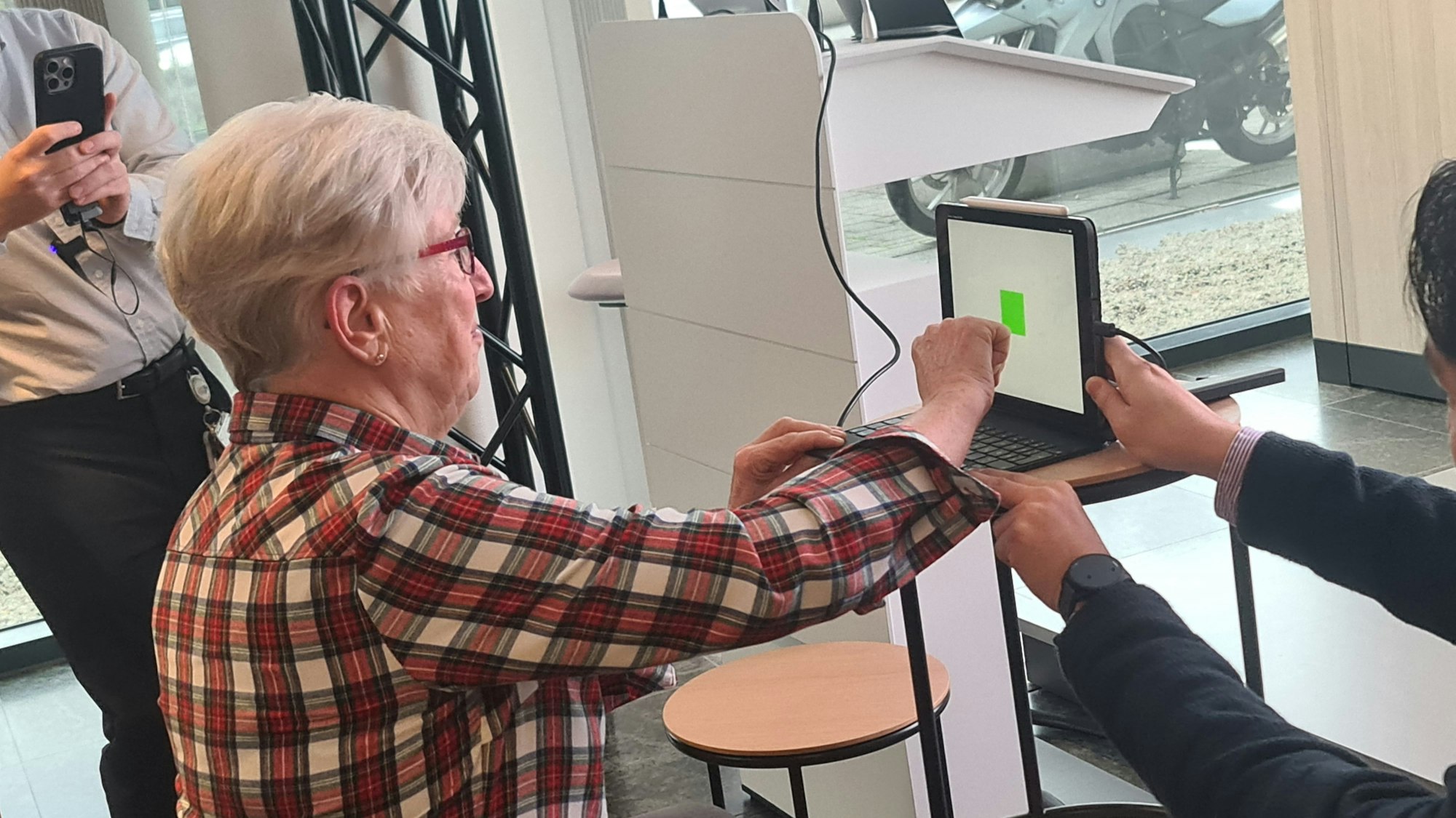 Zu sehen ist eine Workshop-Teilnehmerin in der Seitenansicht, die gerade dabei ist, auf ein Tablet zu tippen.