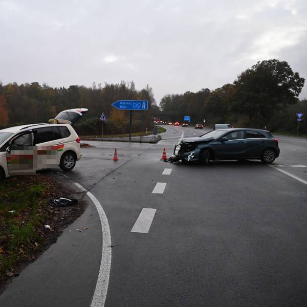 Zwei beschädigte Autos stehen auf einer Straße.