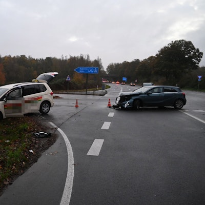 Zwei beschädigte Autos stehen auf einer Straße.